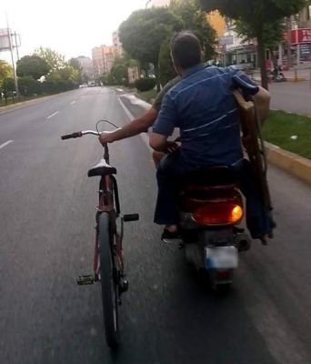 Bir Eliyle Motosiklet Diğer Eliyle De Bisiklet Kullandı