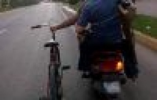 Bir Eliyle Motosiklet Diğer Eliyle De Bisiklet Kullandı